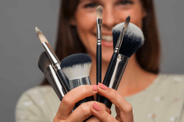 Frau hält alle Make-up Pinsel (Kosmetikpinsel) von REFLECTIVES in der Hand.